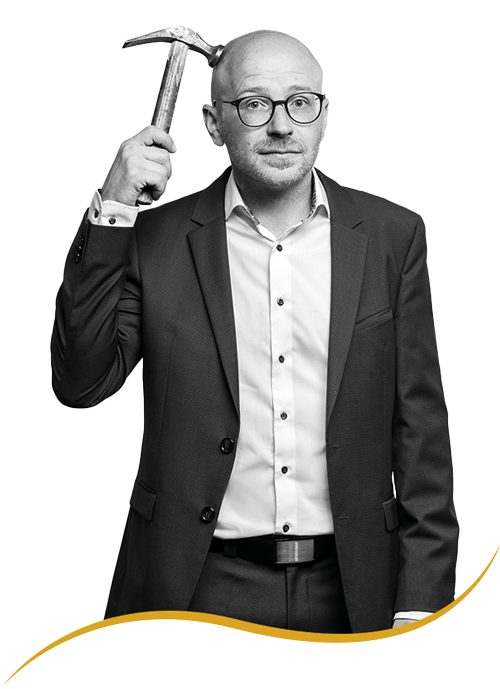 Werner Schmid von Schmid & Co. schlägt sich angesichts rechtlicher Regularien mit einem Hammer auf den Kopf